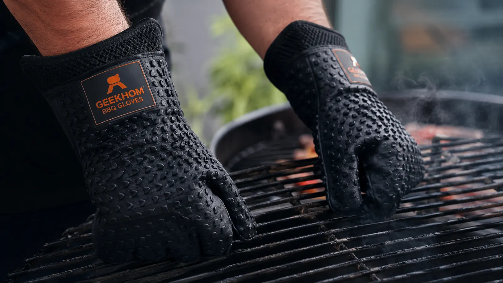 Griller gripping a hot grill grate barehanded while wearing silicone gloves showing the grip texture
