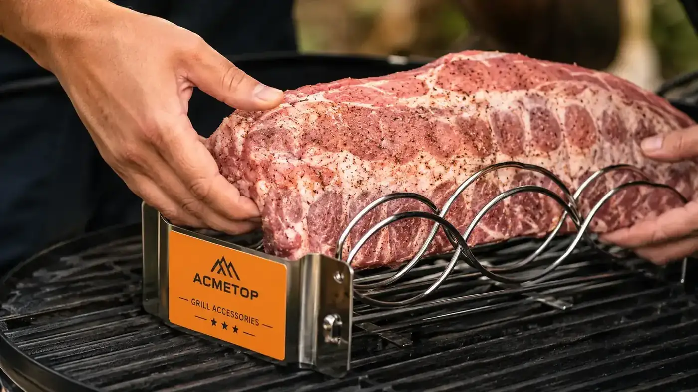 Hands placing a rack of ribs into a stainless steel rib rack sitting on a grill grate